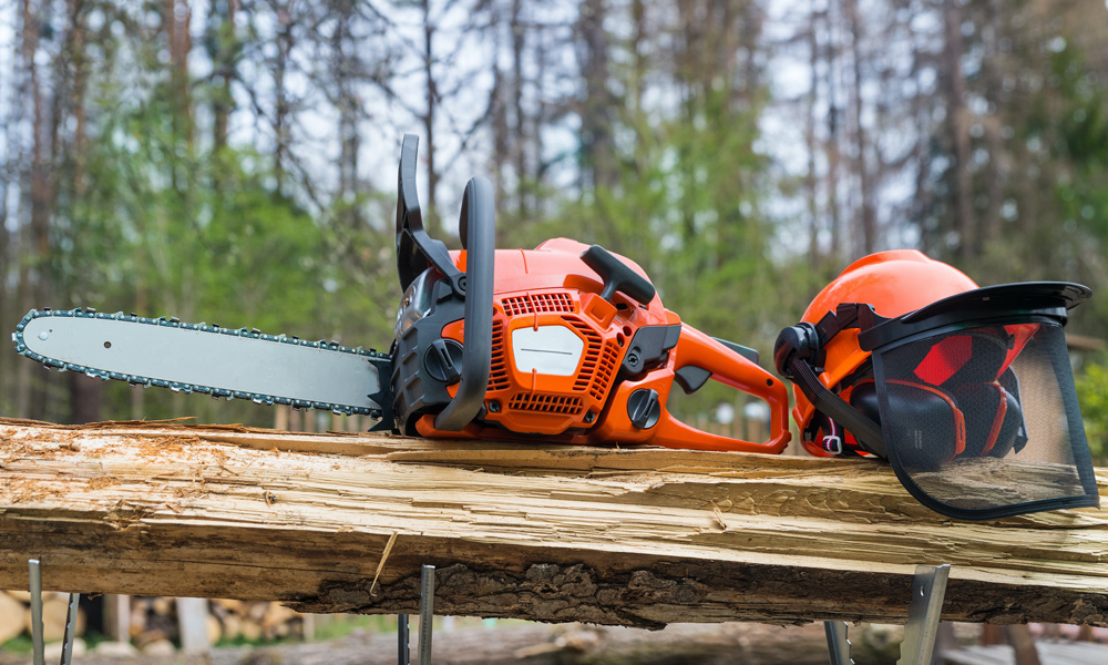 Chainsaw and safety helmet on a log
