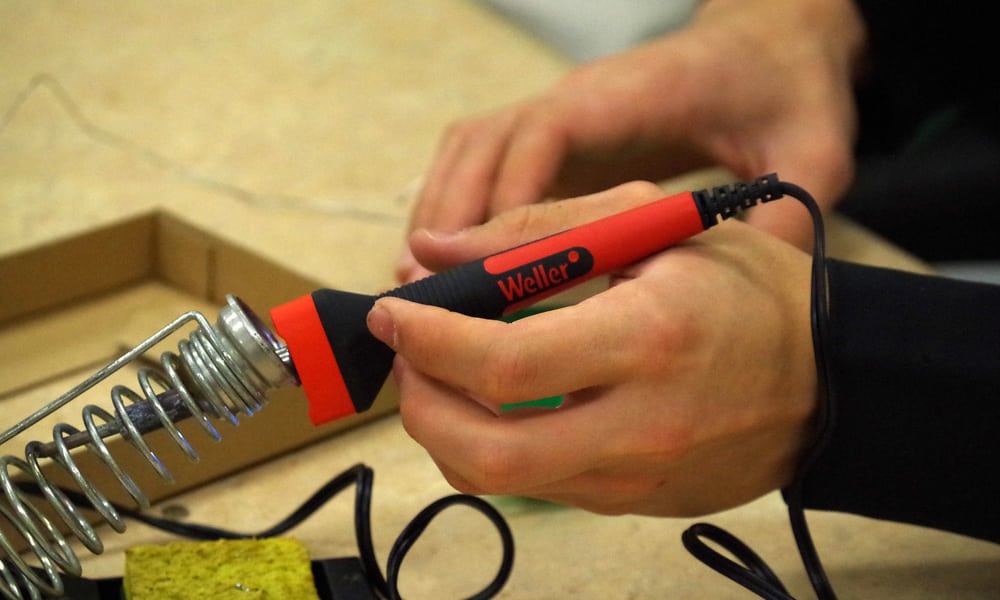 someone holding a soldering iron